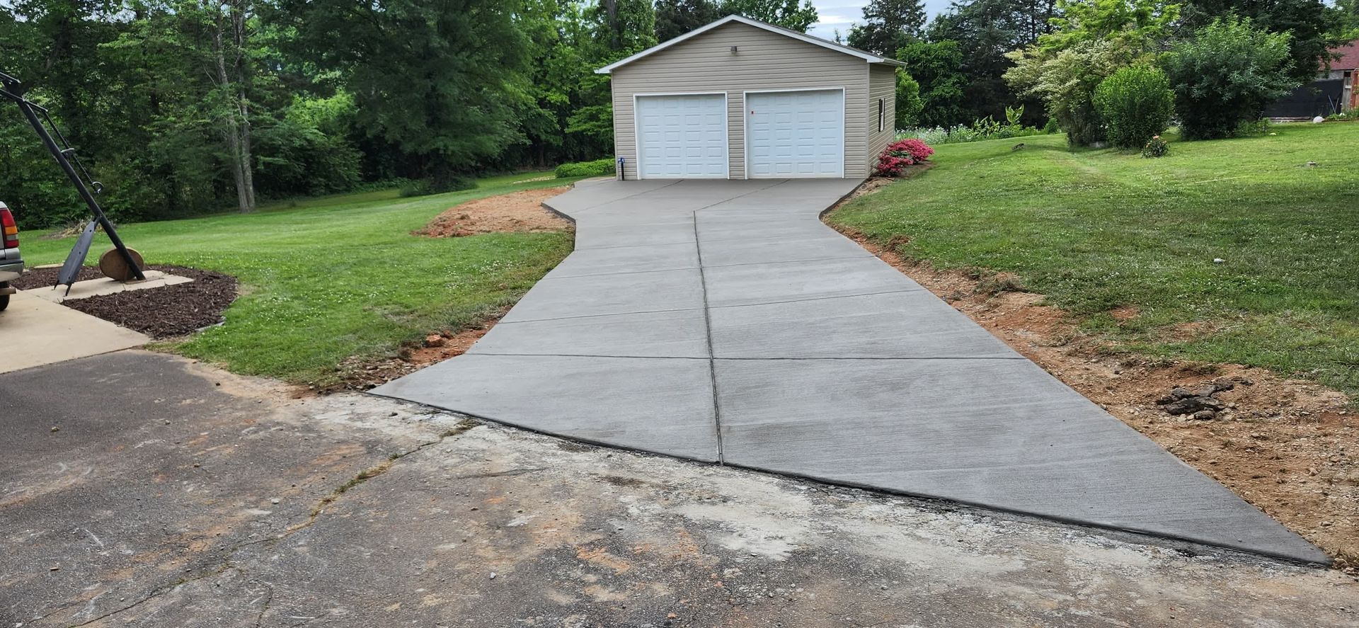 Driveway leading to a two-car garage with green lawn on either side.