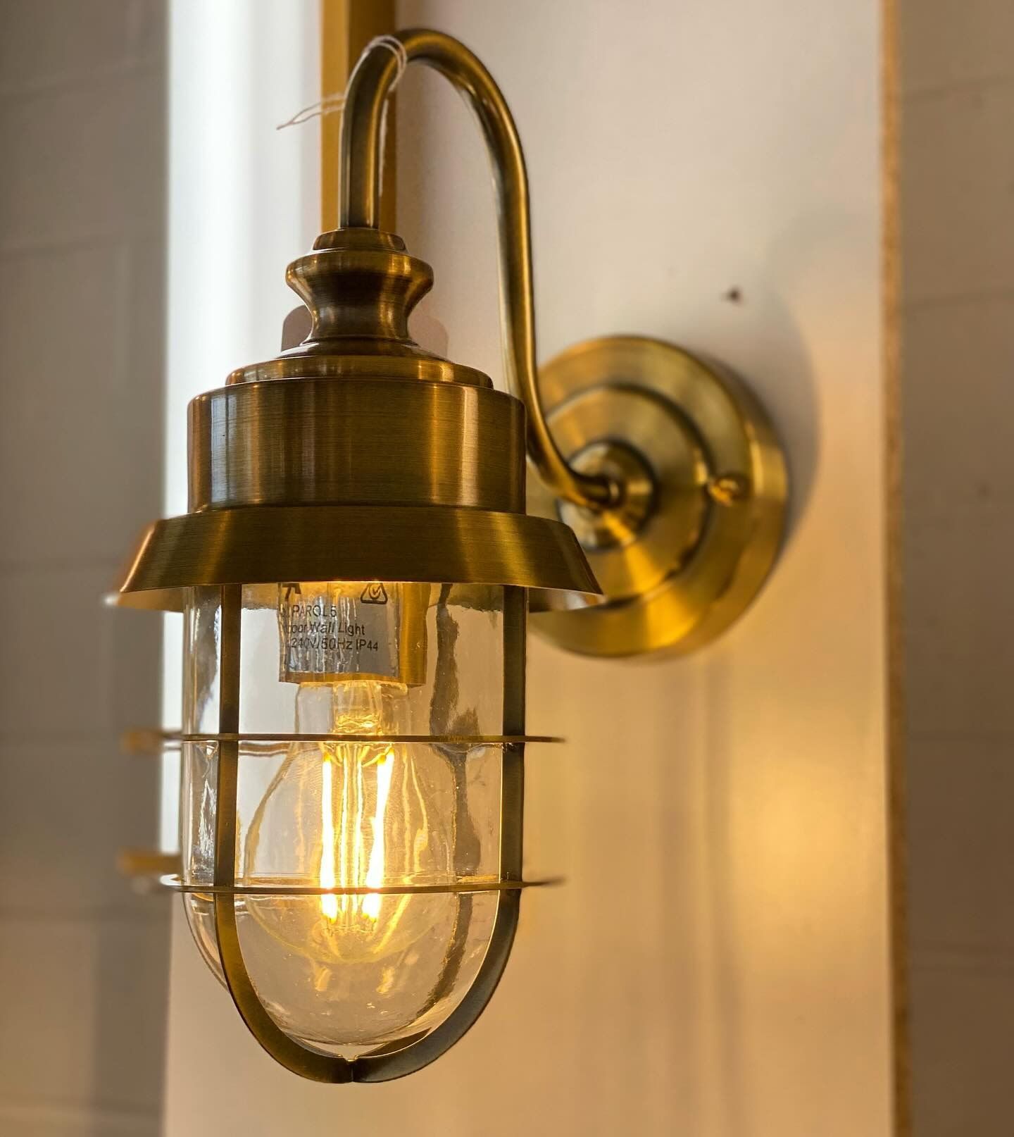A Brass Wall Light With a Light Bulb Inside of It — Brightway Lighting in Lismore, NSW