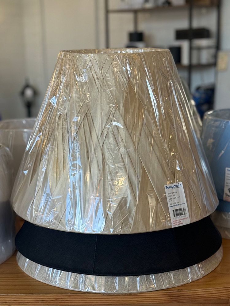 Stack Of Beige Lampshades Wrapped In Plastic — Brightway Lighting in Lismore, NSW