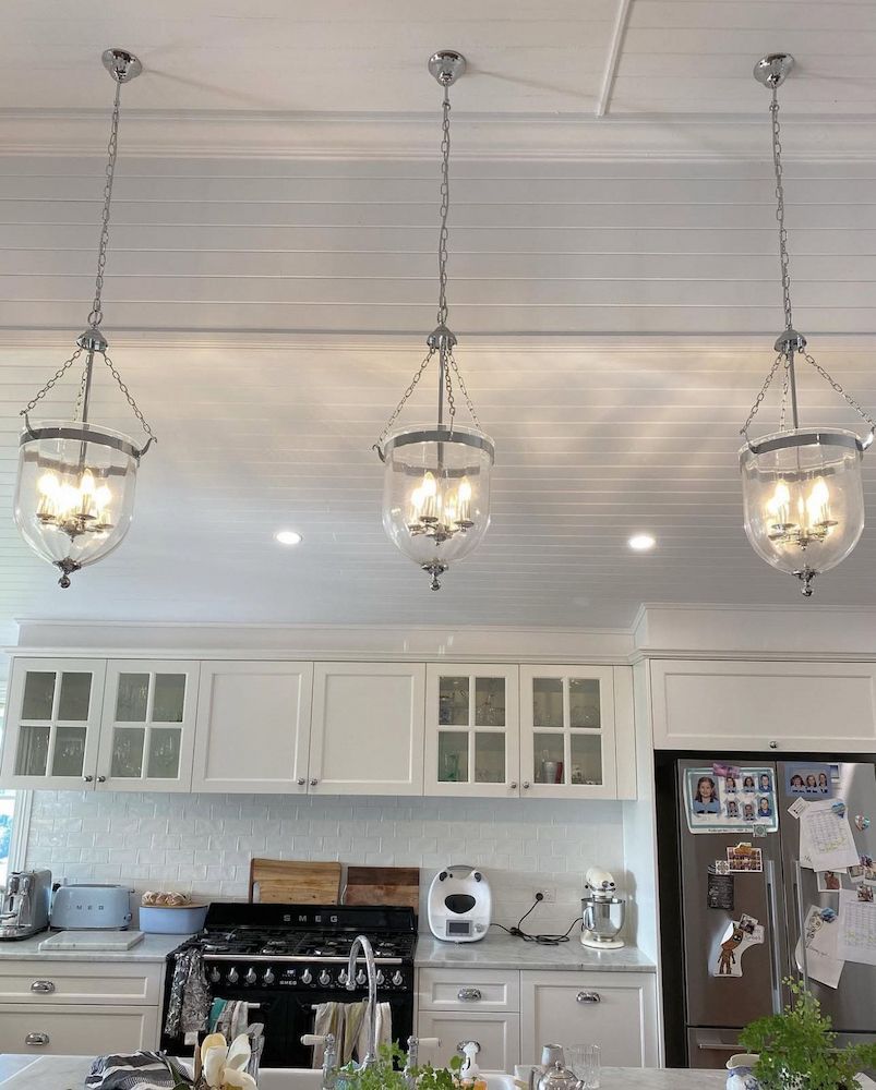 Three Hanging Pendant Lights Over a White Kitchen Island — Brightway Lighting in Lismore, NSW