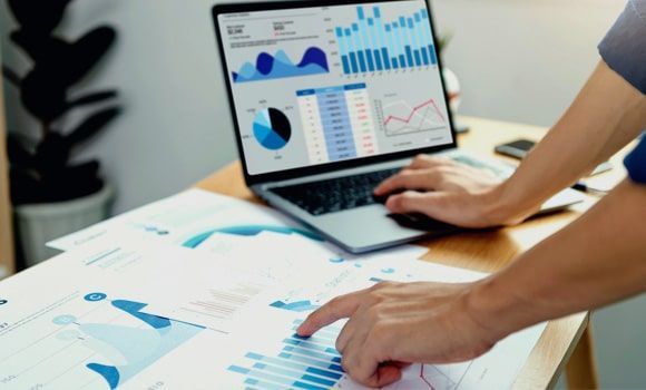 Una persona está usando una computadora portátil con gráficos en la pantalla.