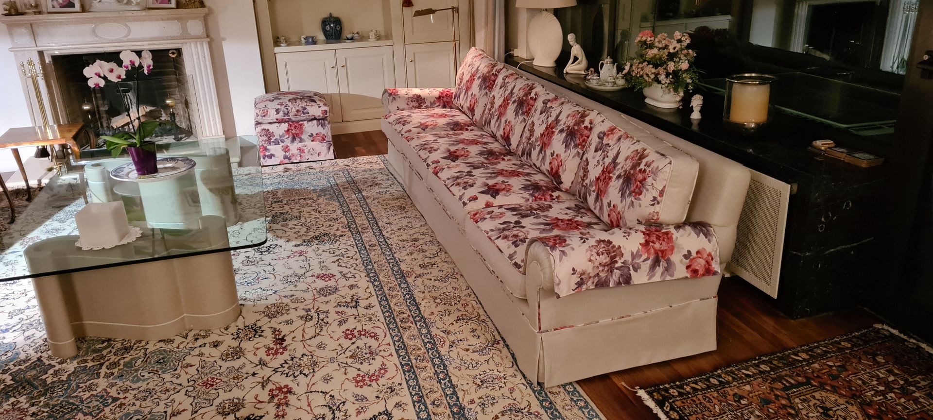 Ein Wohnzimmer mit einer langen Couch und einem Kamin