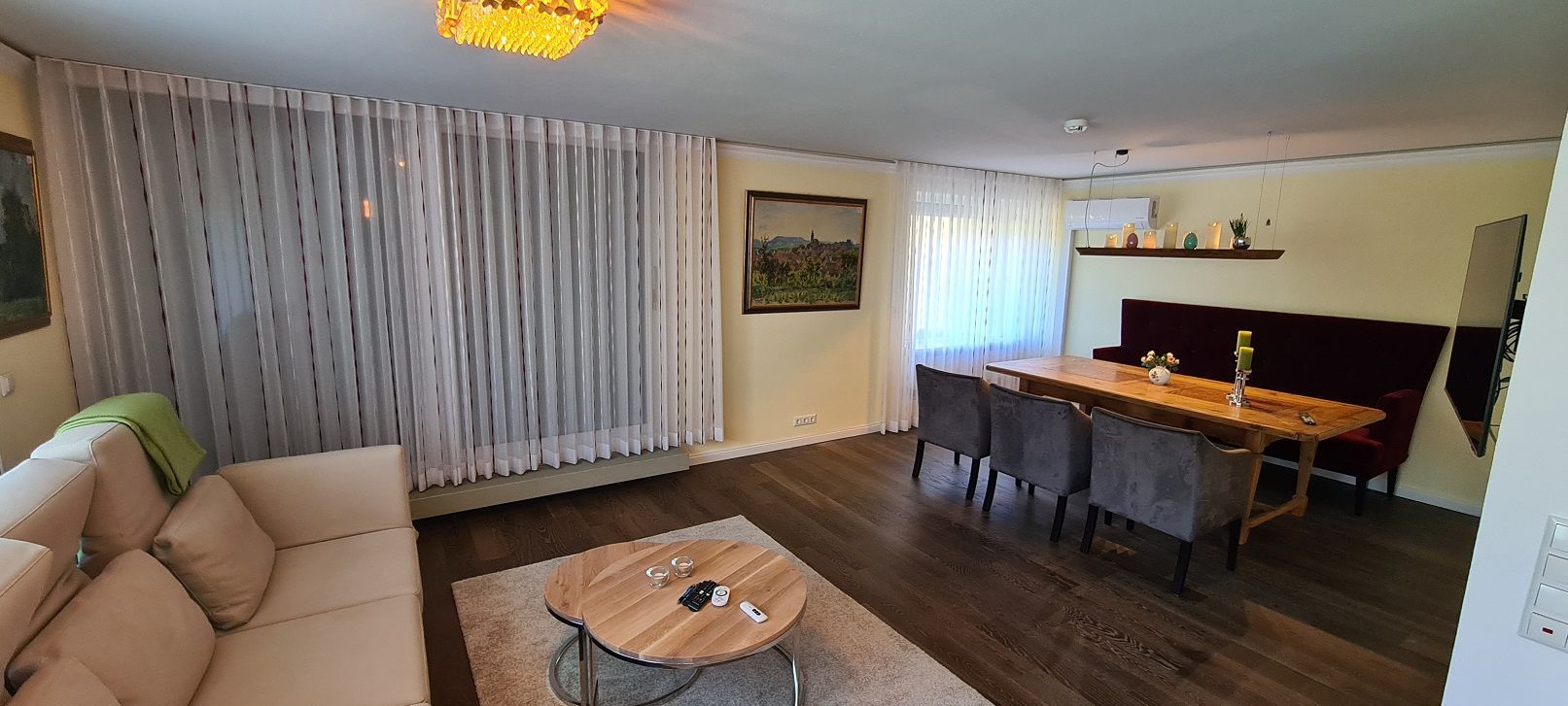 Ein Wohnzimmer mit Sofa, Tisch und Stühlen.