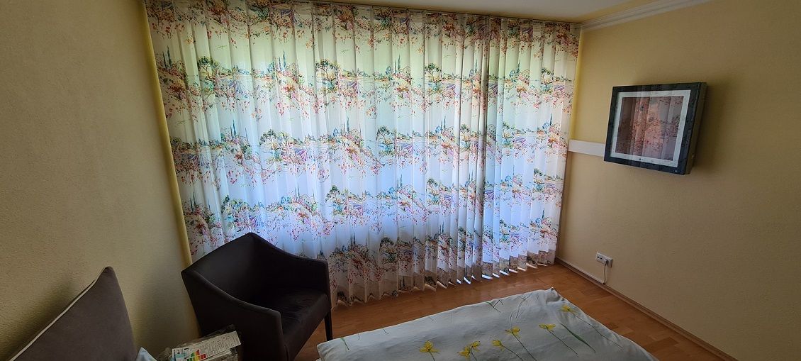 Ein Wohnzimmer mit einem Sessel und einem Fernseher an der Wand.