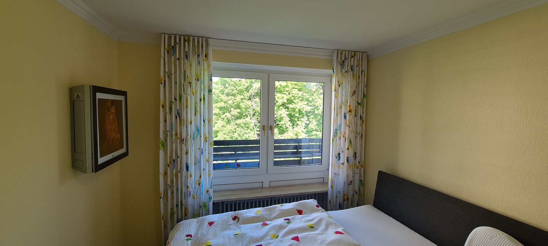Ein Schlafzimmer mit Bett, Fernseher und Fenster.