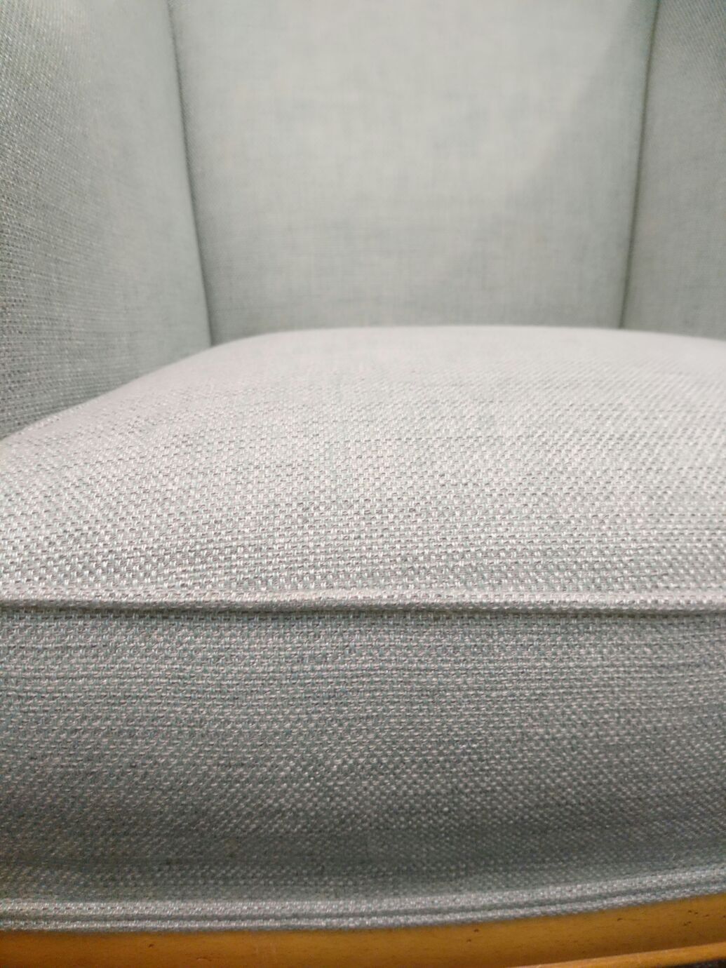 Eine Nahaufnahme der Rückenlehne eines Stuhls mit Holzrahmen.