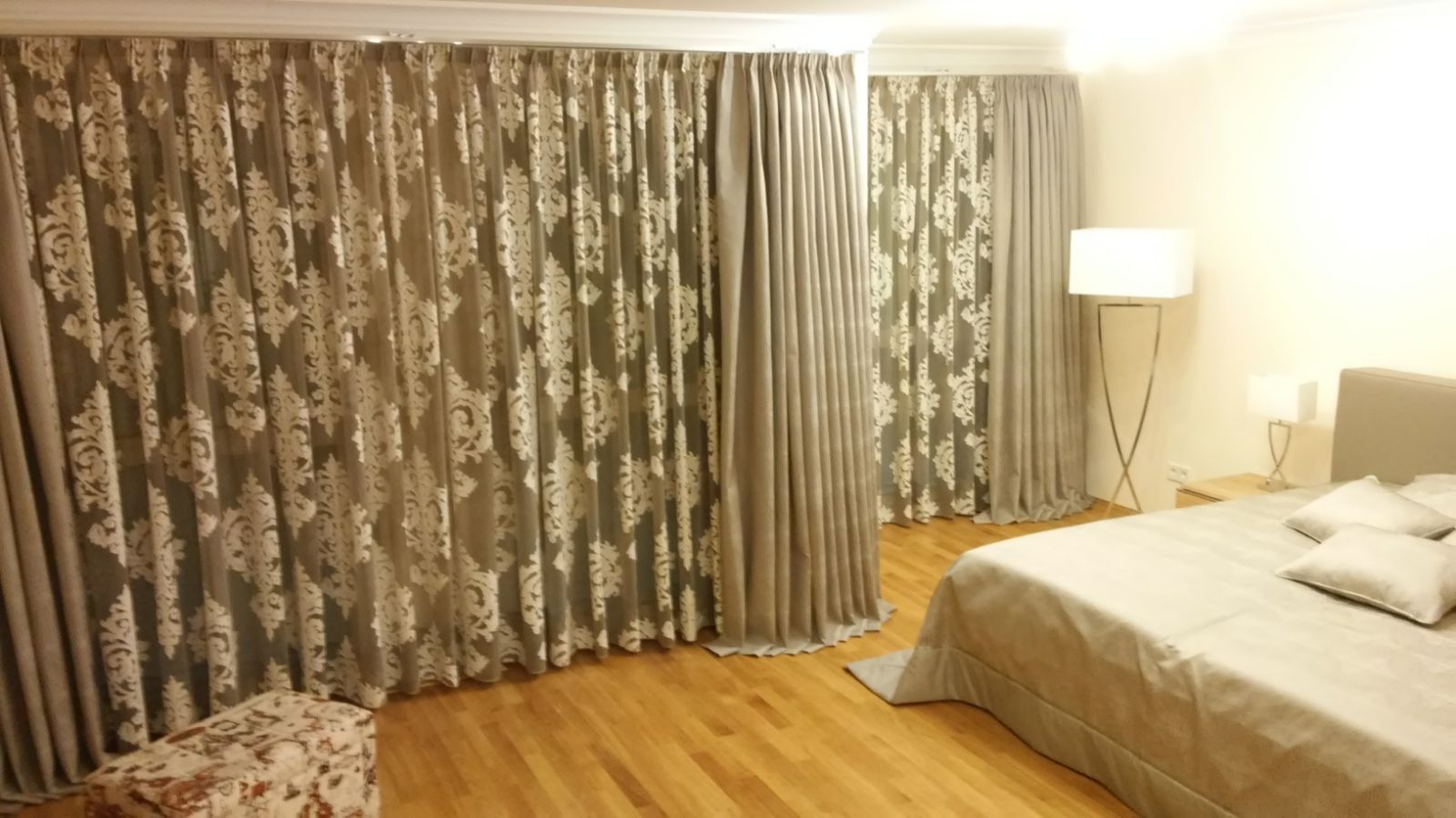 Ein Schlafzimmer mit einem Bett, Vorhängen und einer Lampe