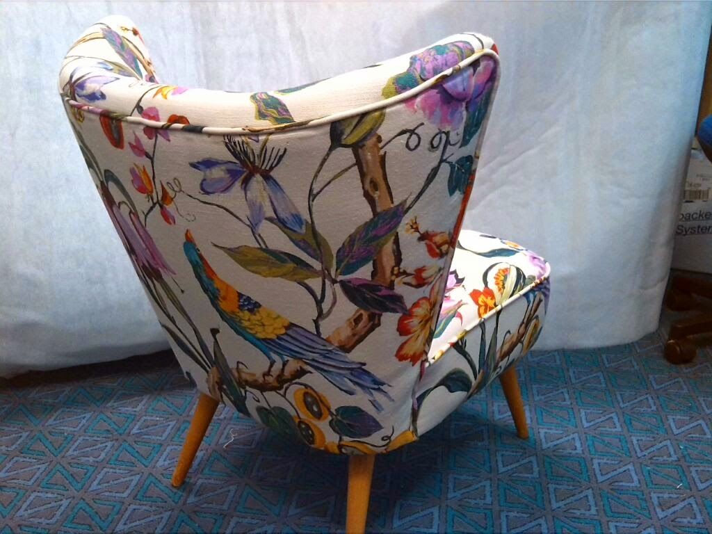 Auf einem blauen Teppich steht ein Stuhl mit Blumenmuster.