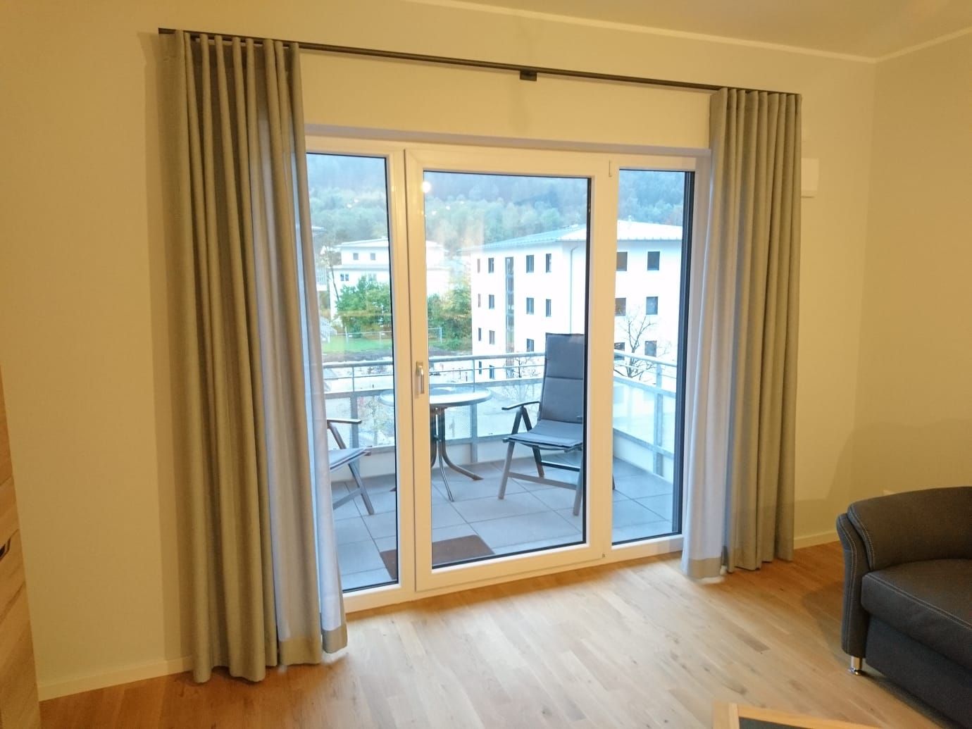 Ein Wohnzimmer mit einer Glasschiebetür, die auf einen Balkon führt
