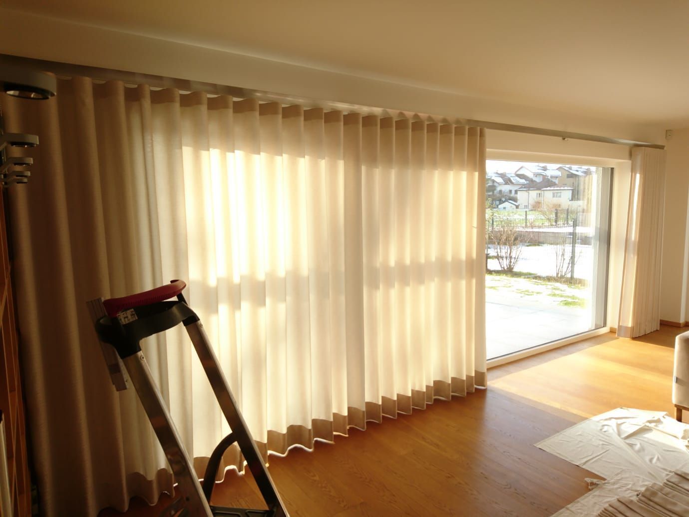 Ein Wohnzimmer mit Glasschiebetüren und weißen Vorhängen