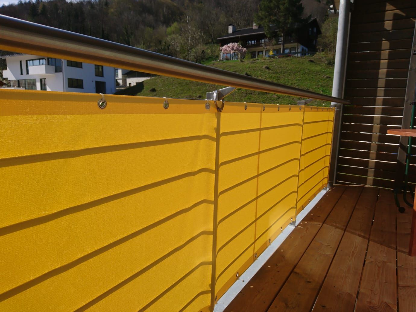 Ein Balkon mit einem gelben Zaun und einem Geländer aus Edelstahl