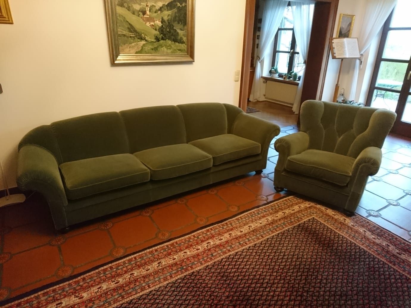 Ein Wohnzimmer mit einem grünen Sofa und einem grünen Sessel