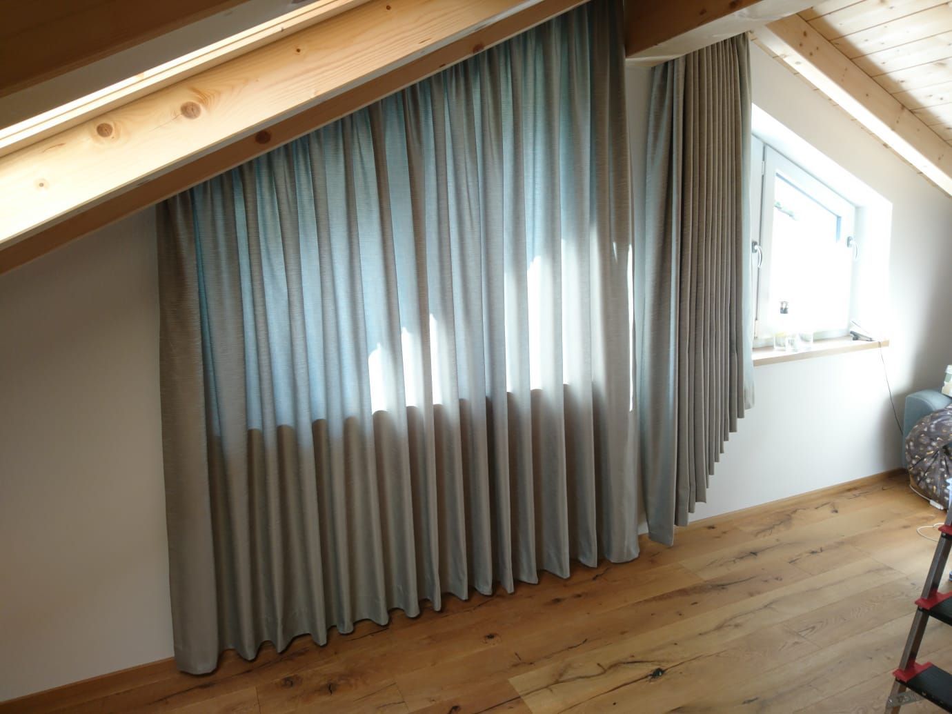 Ein Raum mit einem Fenster und Vorhängen.