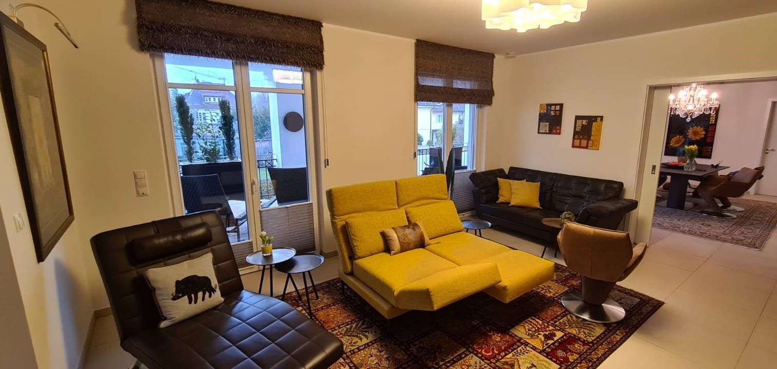 Ein Wohnzimmer voller Möbel und einem gelben Sofa.