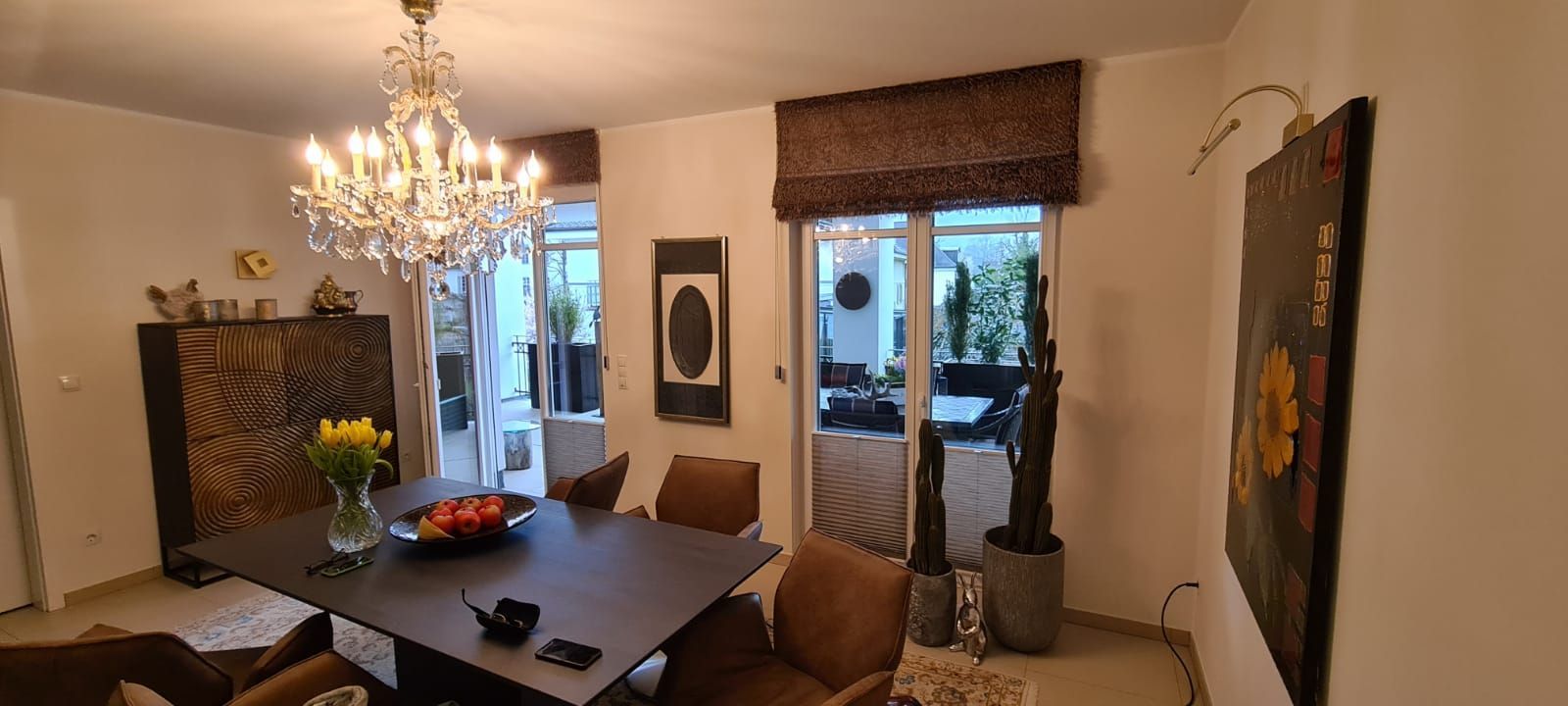 Ein Wohnzimmer mit einem Tisch, Stühlen und einem Kronleuchter.
