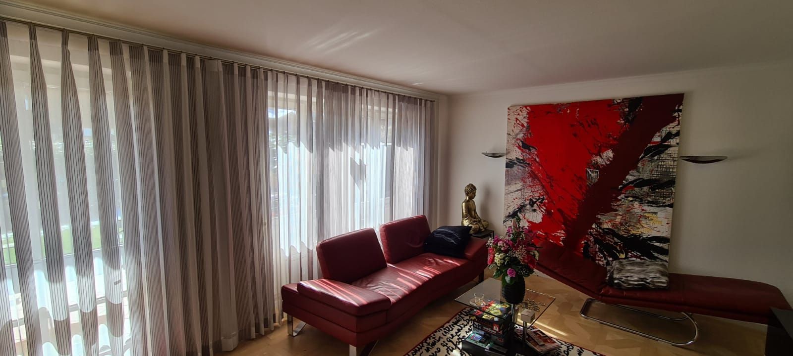 Ein Wohnzimmer mit einem Sofa und einem Gemälde an der Wand.