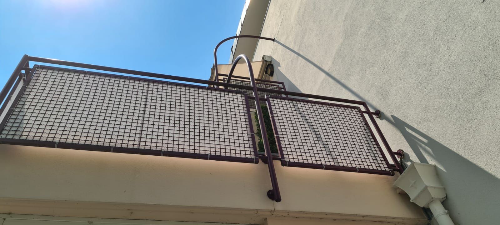 Ein Balkon mit einem Metallgeländer an der Seite eines Gebäudes.