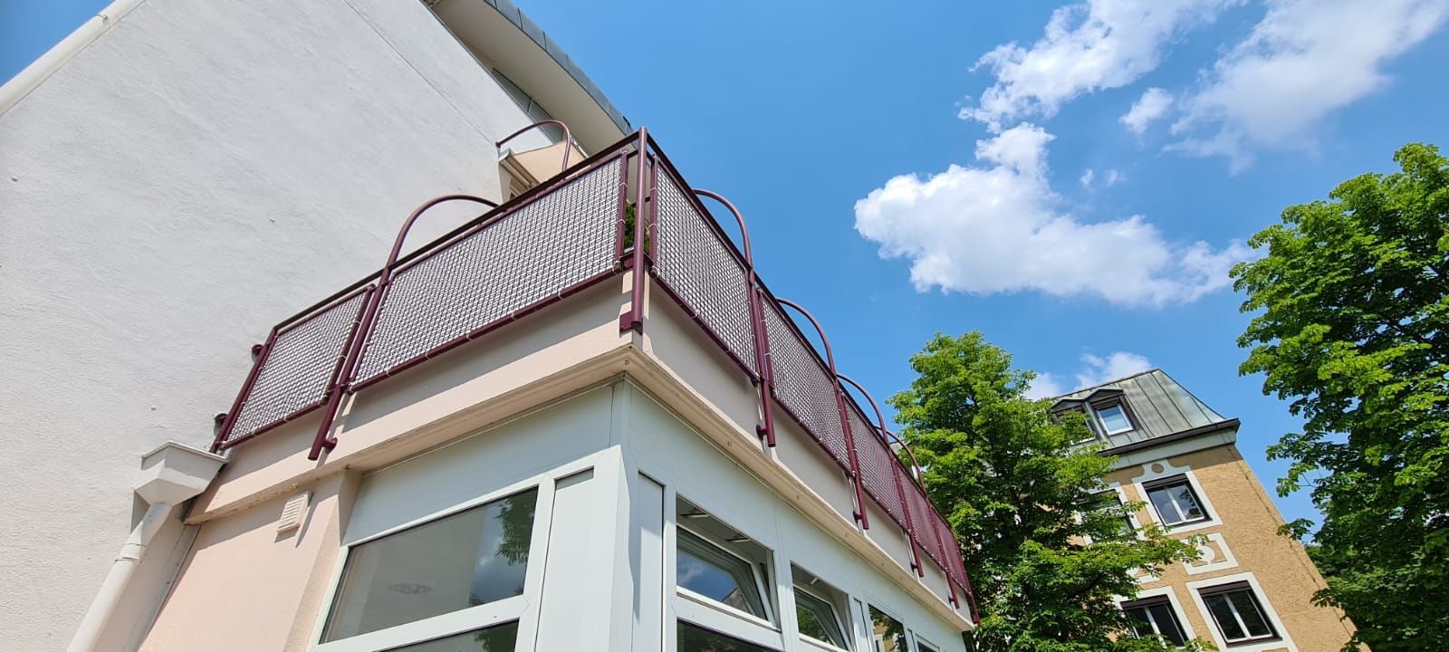 Ein Gebäude mit einem Balkon und einem blauen Himmel im Hintergrund