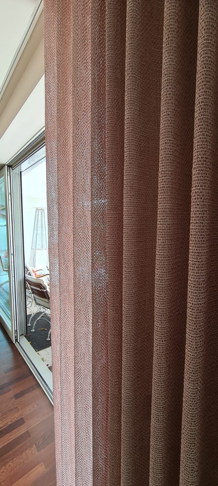 Eine Nahaufnahme eines Vorhangs in einem Wohnzimmer neben einer Glasschiebetür.