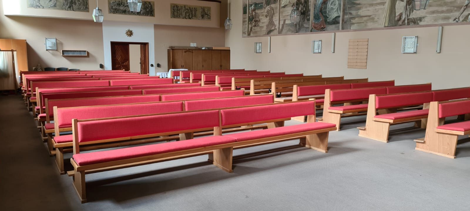 Eine Kirche mit Reihen roter Bänke darin