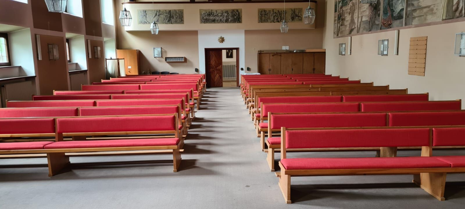 Eine Kirche mit Reihen roter Bänke darin