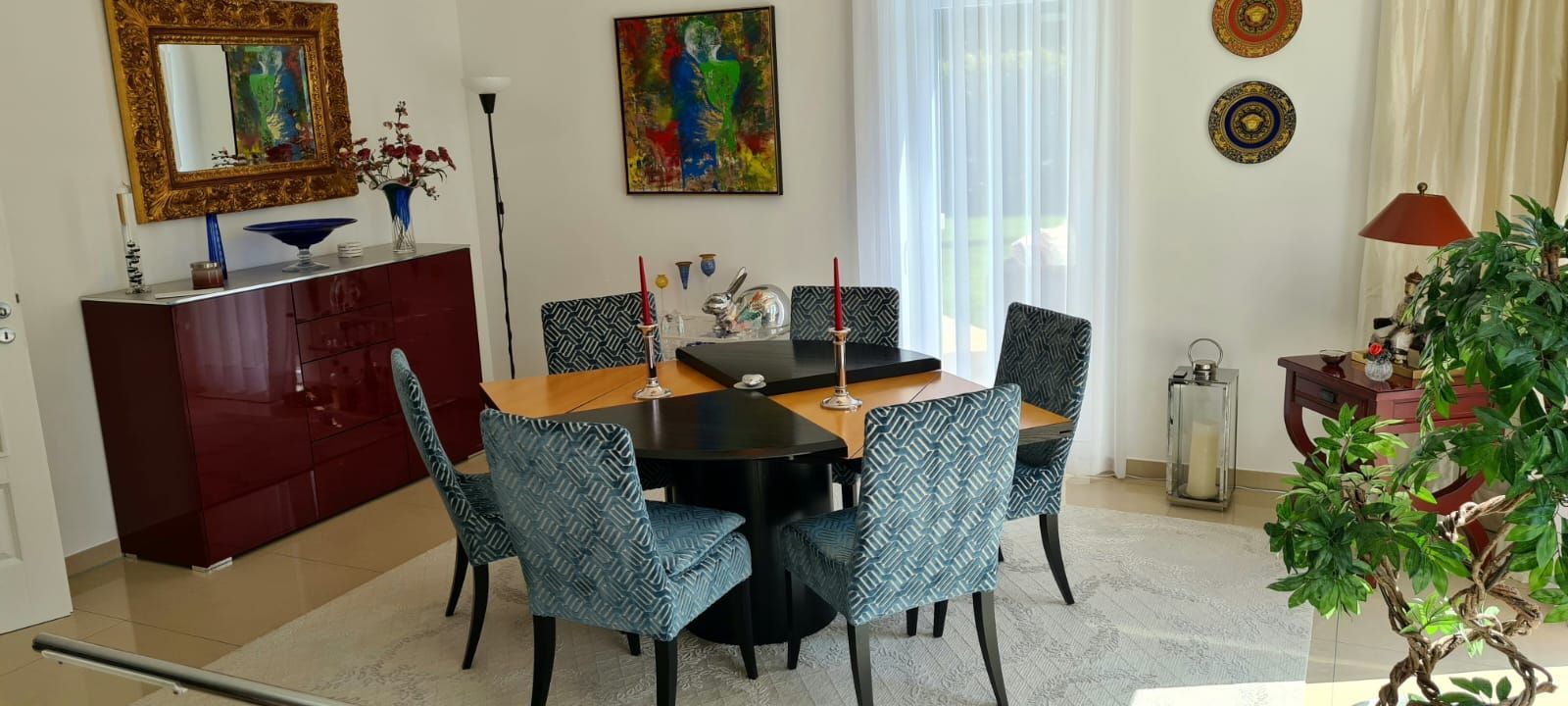 Ein Esszimmer mit einem Tisch und Stühlen und einem Gemälde an der Wand.