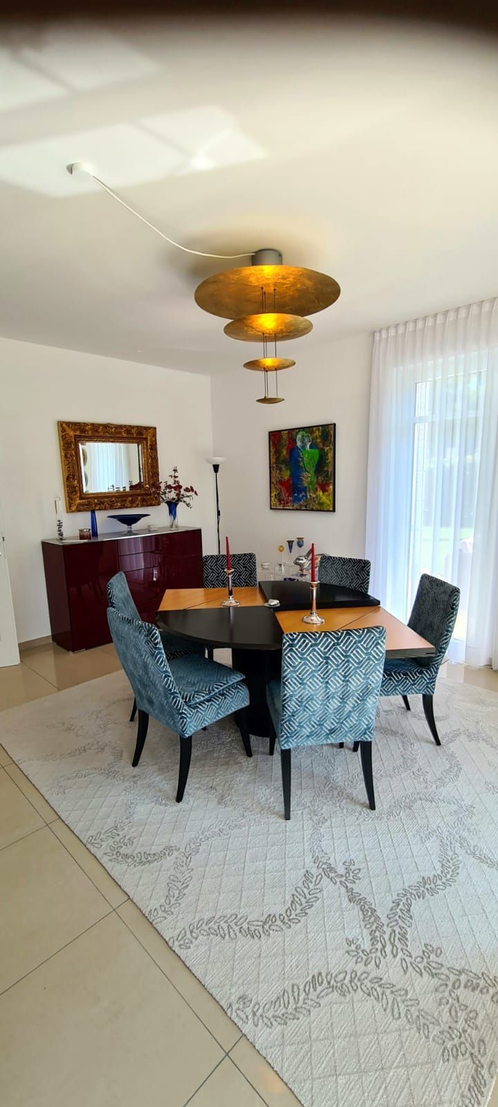 Ein Esszimmer mit Tisch, Stühlen und einem Teppich.