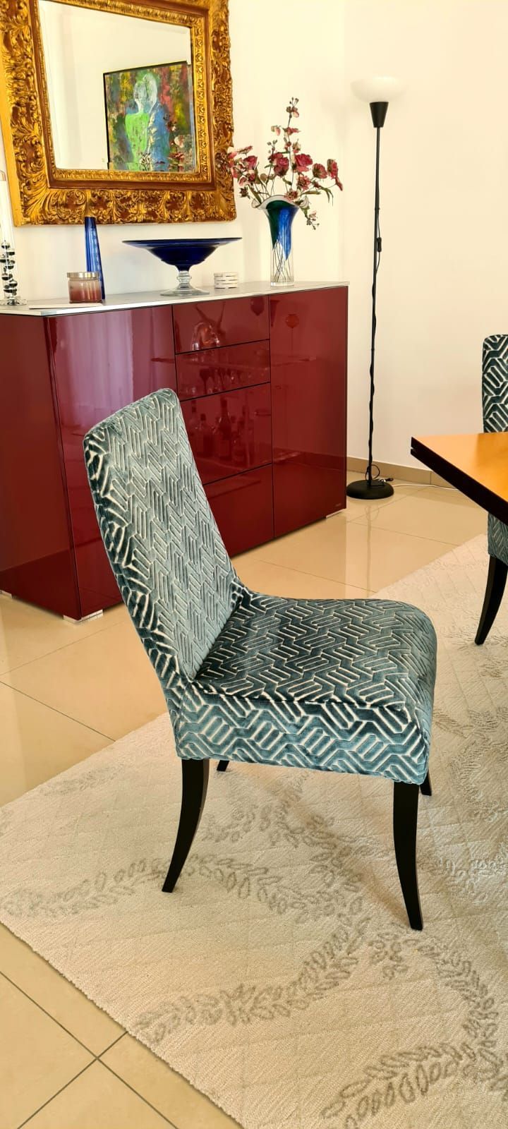 In einem Wohnzimmer steht ein Stuhl neben einem Tisch und einem Spiegel.