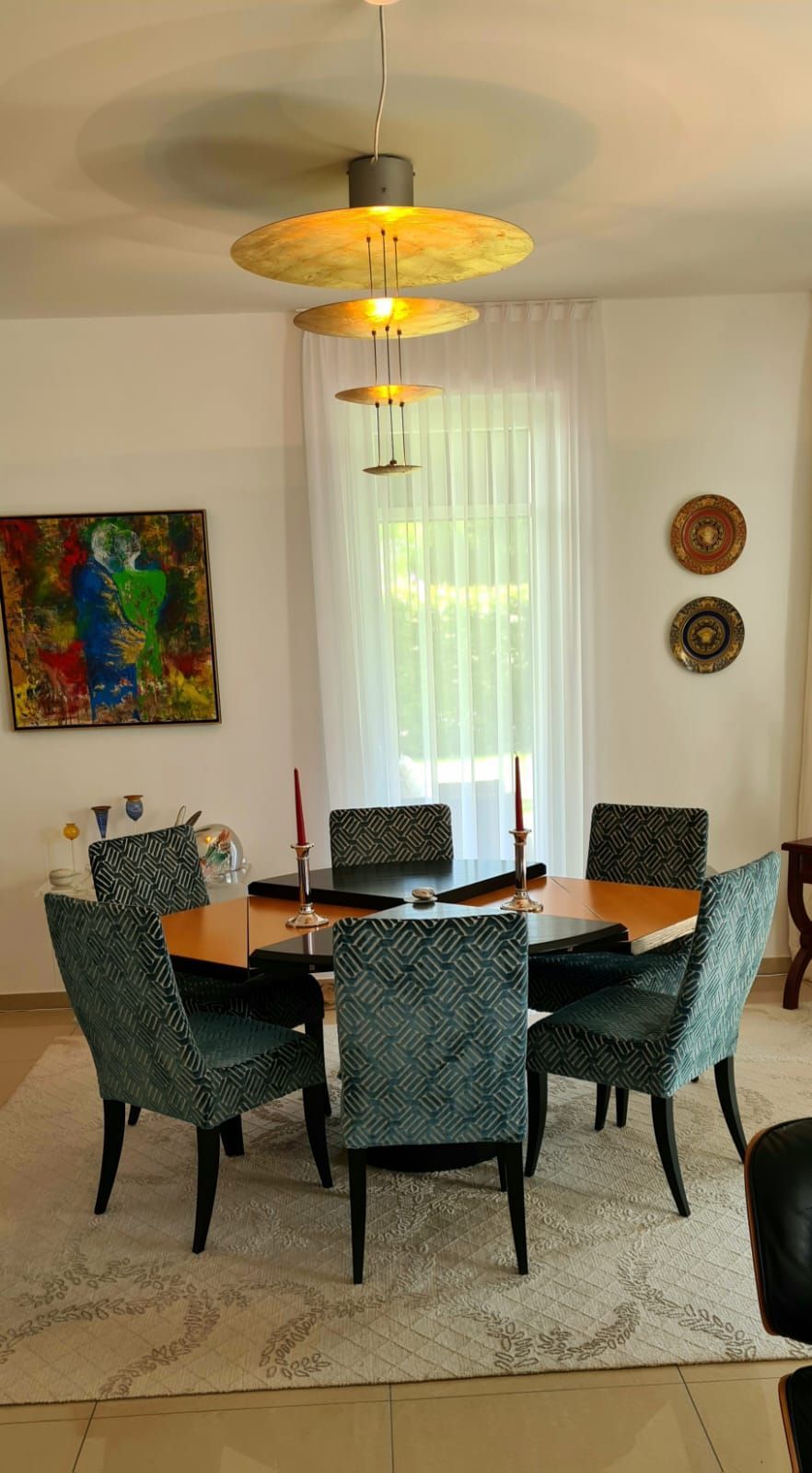 Ein Esszimmer mit einem Tisch und Stühlen und einem Gemälde an der Wand.