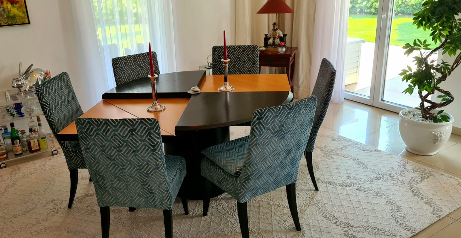 Ein Esszimmer mit Tisch und Stühlen und einer Pflanze