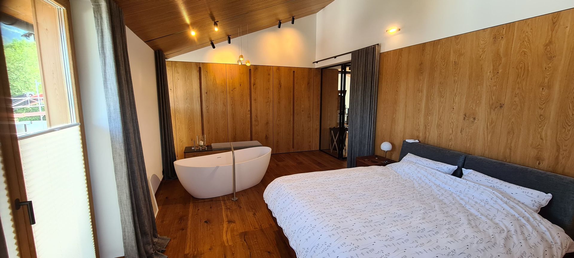 Ein Schlafzimmer mit Bett, Badewanne und Holzwänden.