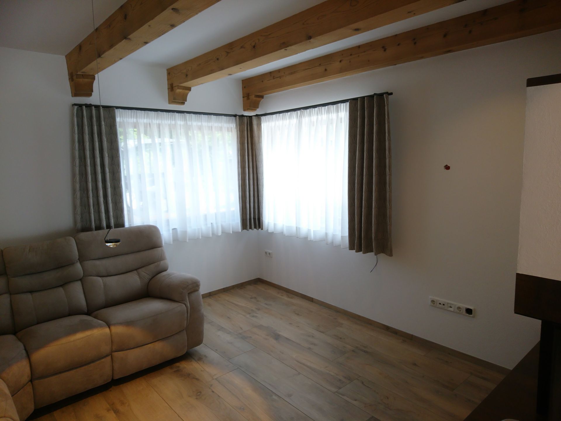 Ein Wohnzimmer mit einer Couch und zwei Fenstern
