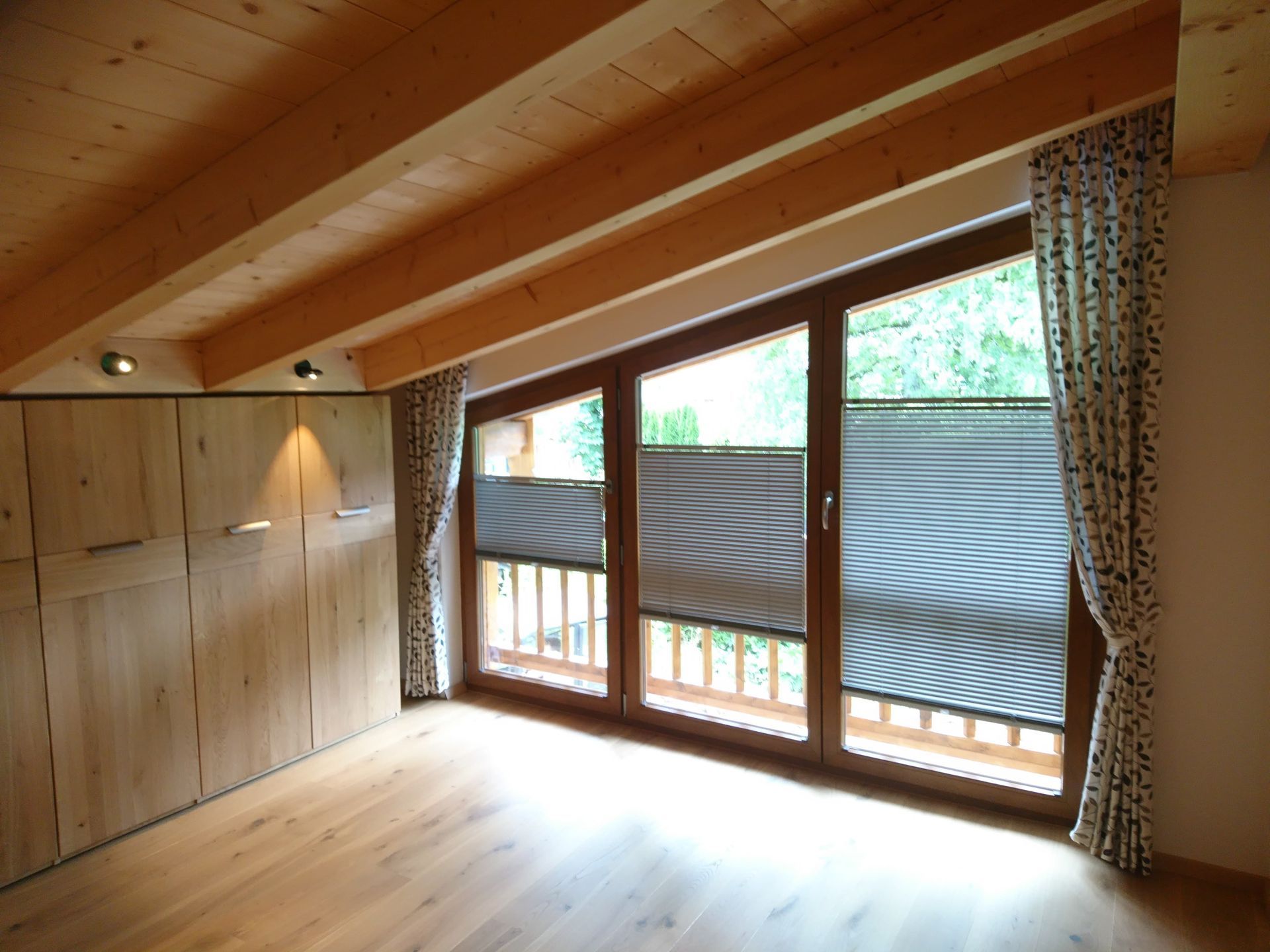 Ein Zimmer mit vielen Fenstern und einem Balkon