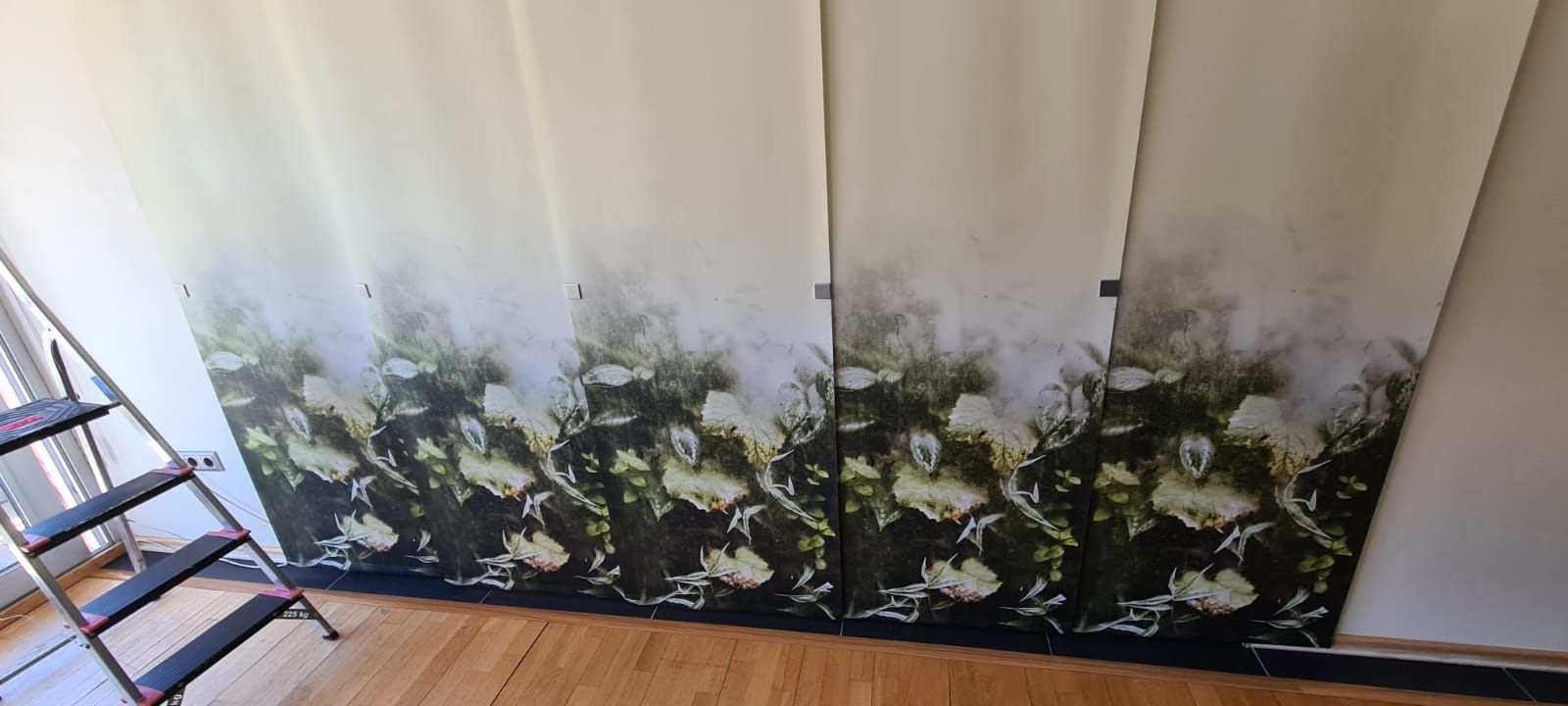 Ein Raum mit einer Leiter und einem Gemälde an der Wand.