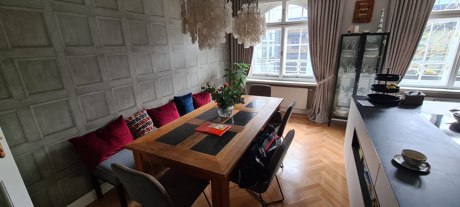 Ein Esszimmer mit einem Holztisch und Stühlen und einem Fenster.