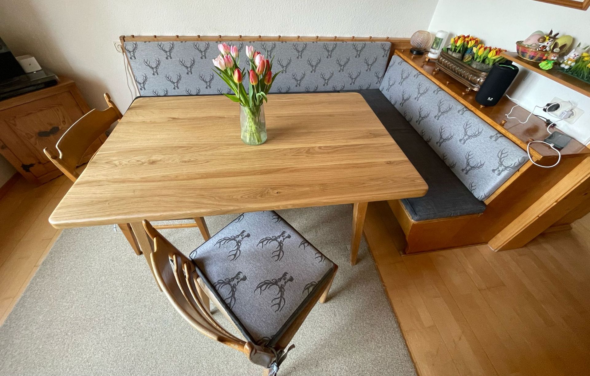 Ein Holztisch mit einer Vase mit Blumen darauf