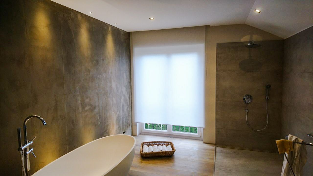 Ein Badezimmer mit Badewanne und ebenerdiger Dusche.