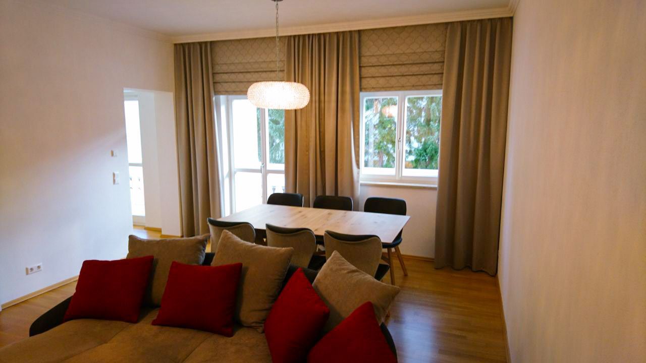 Ein Wohnzimmer mit Sofa, Tisch und Stühlen.