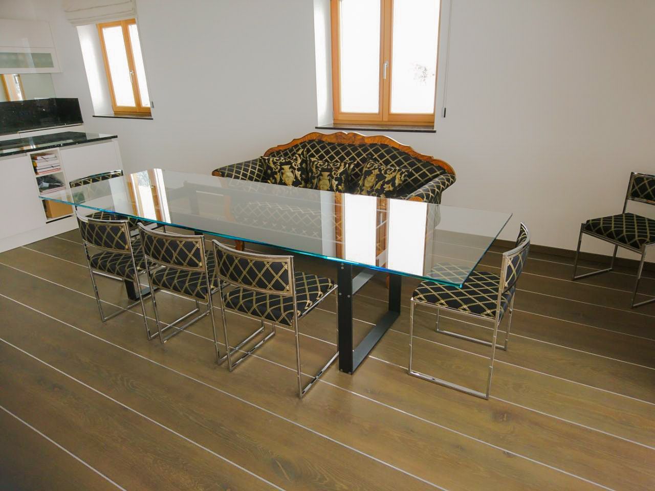 Ein Esszimmer mit einem Glastisch und Stühlen