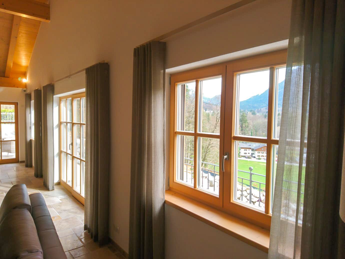 Ein Wohnzimmer mit vielen Fenstern und Vorhängen