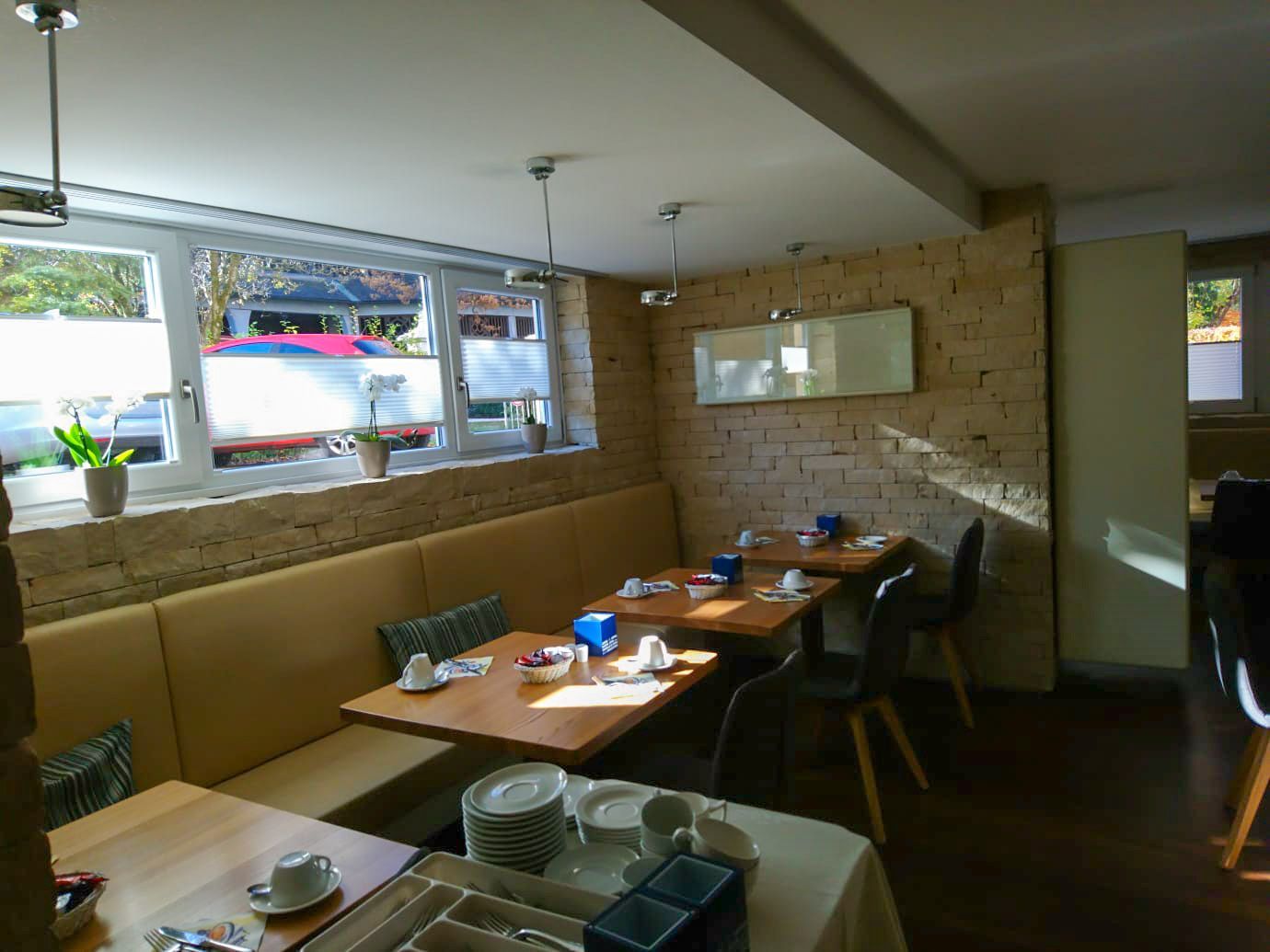 Ein Restaurant mit Tischen und Stühlen und einer Backsteinmauer