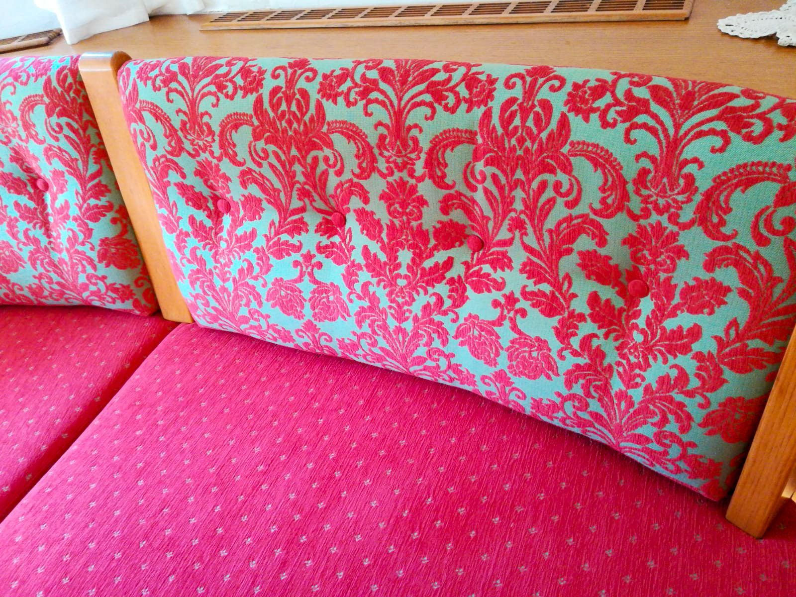 Ein rosa und blaues Sofa mit einem Blumenmuster darauf