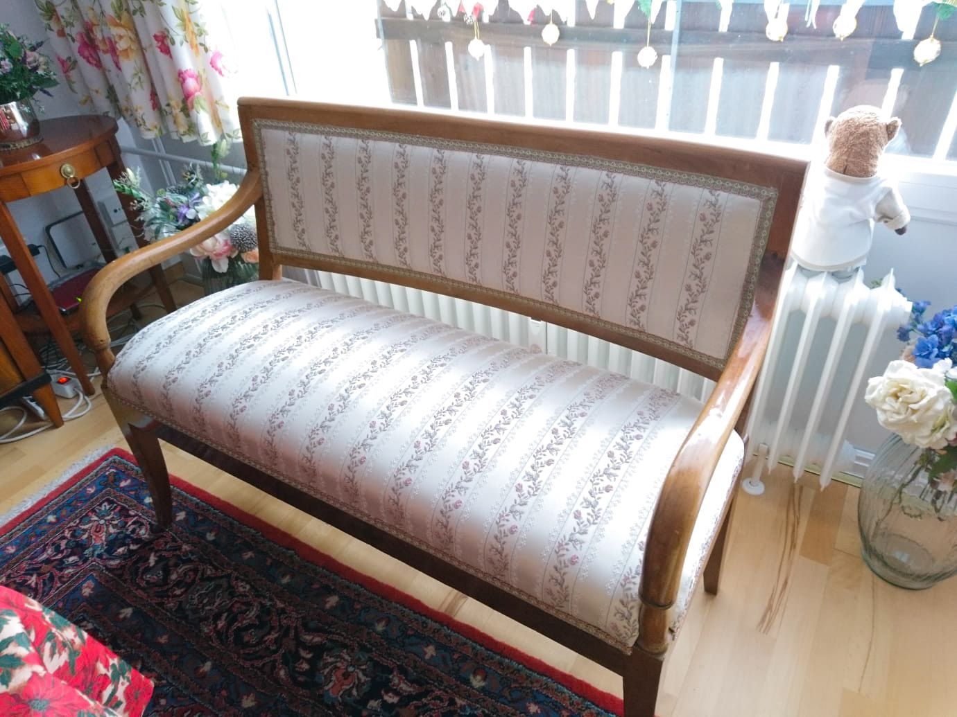 In einem Wohnzimmer steht eine Holzbank neben einem Heizkörper.
