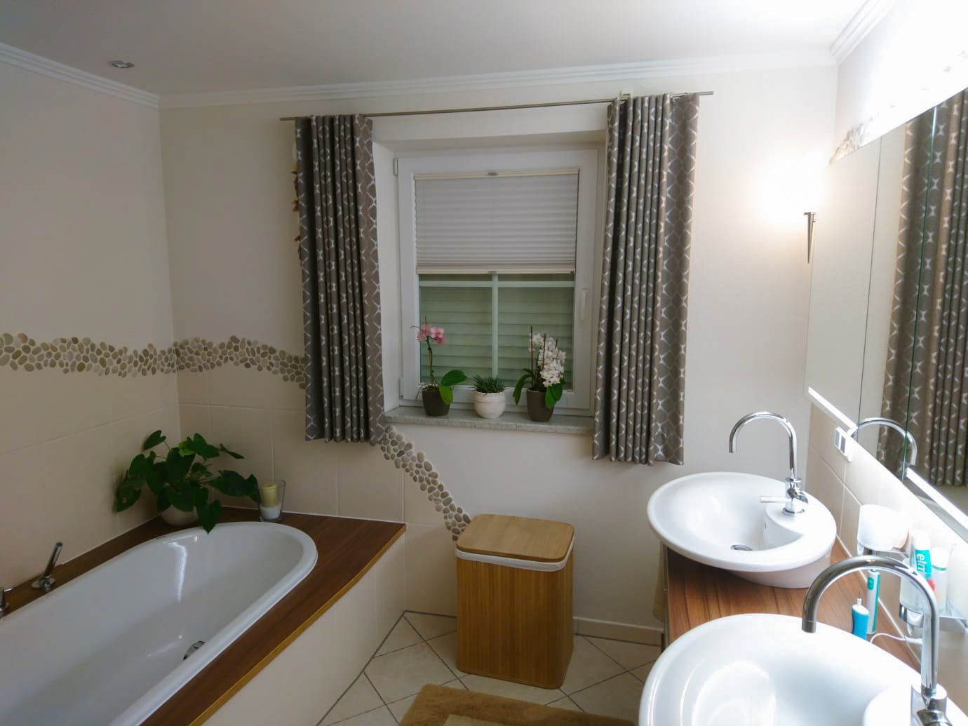 Ein Badezimmer mit zwei Waschbecken, einer Badewanne und einem Fenster