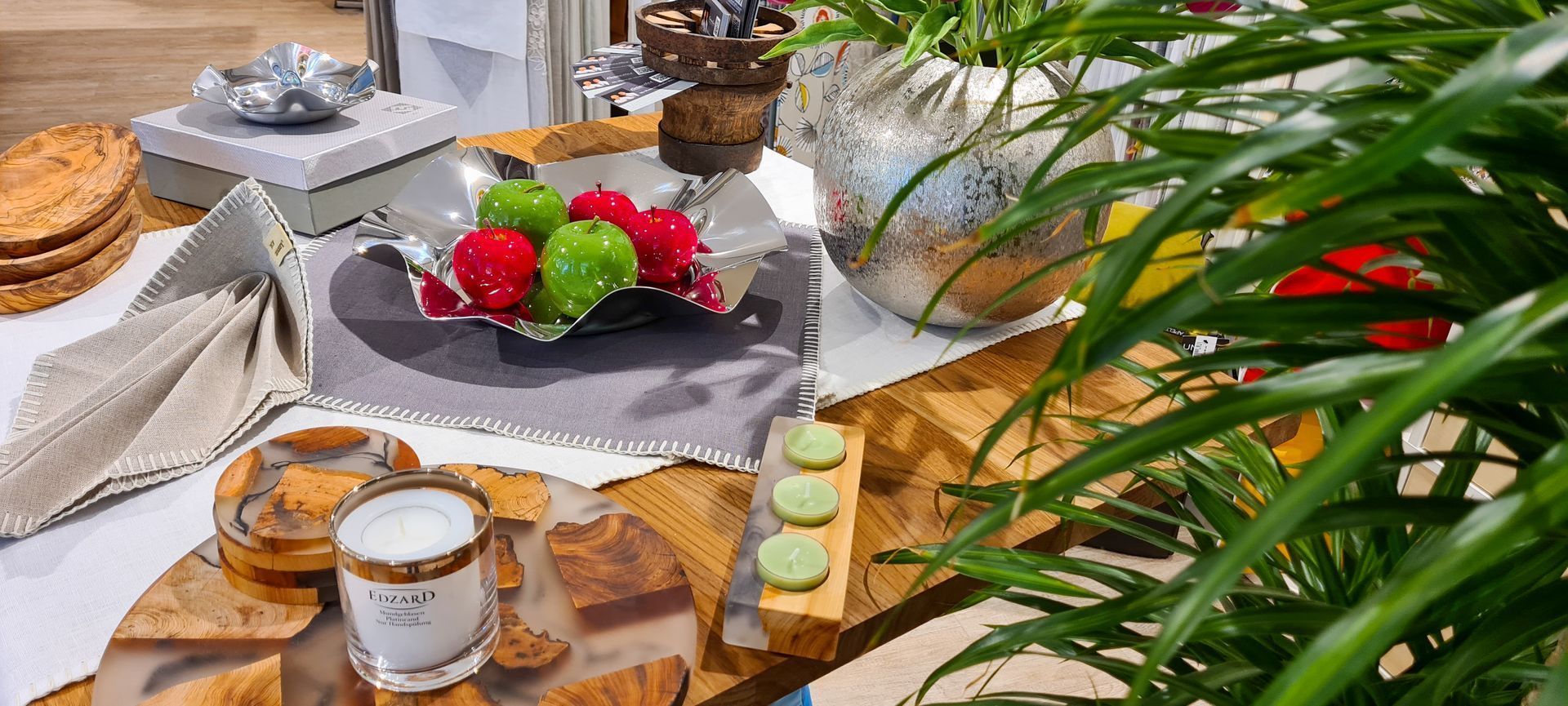 Ein Tisch mit einer Obstschale und einer Kerze darauf.