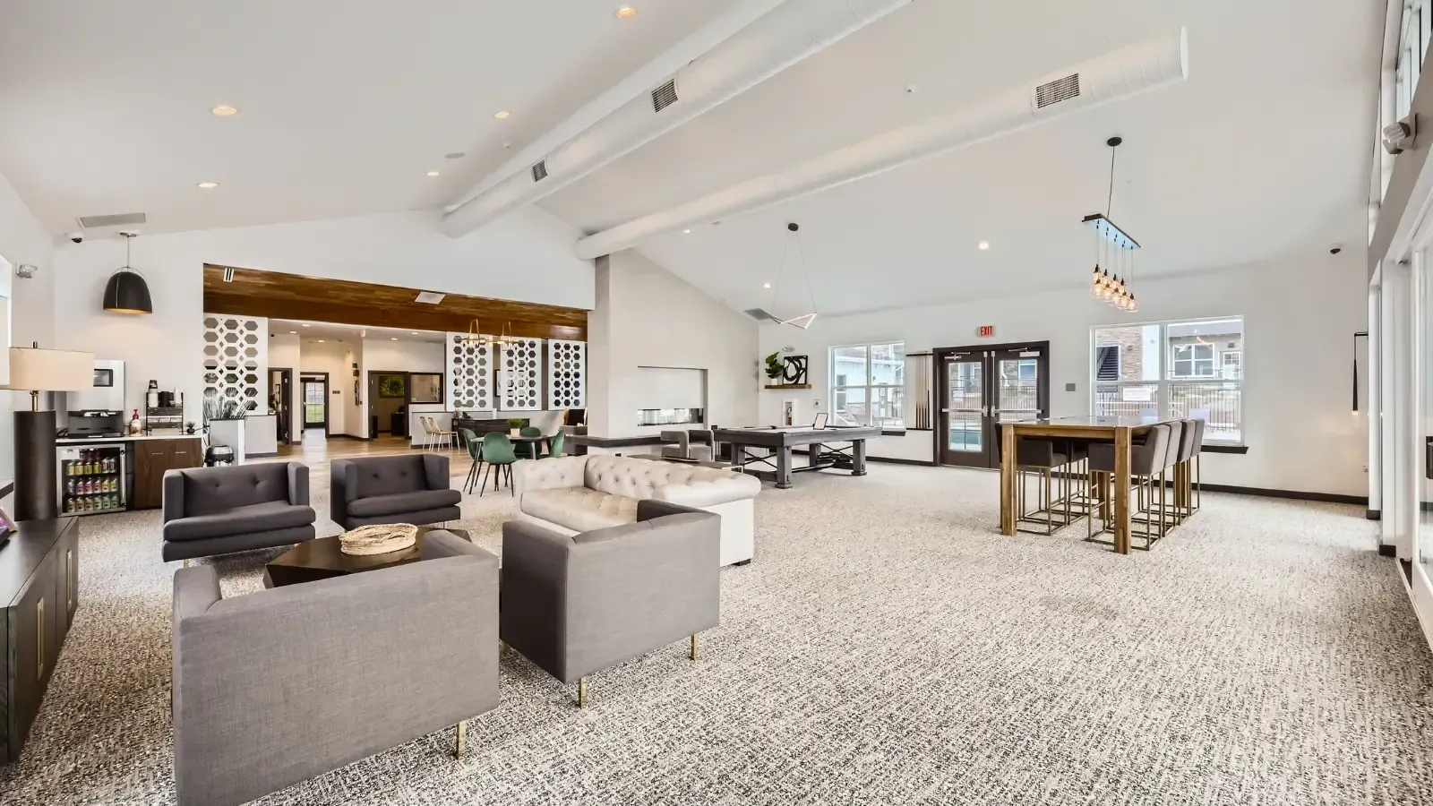 Interior communal lounge in an apartment community with modern seating and a high-top table.