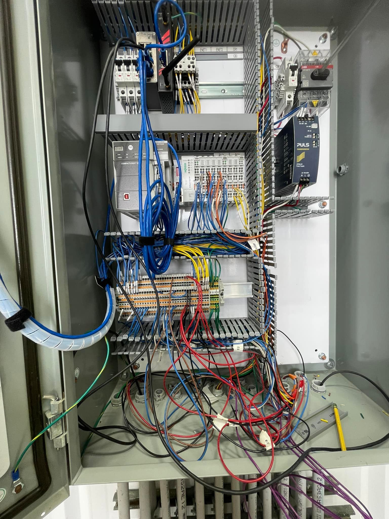 Open electrical control panel filled with wires and components.