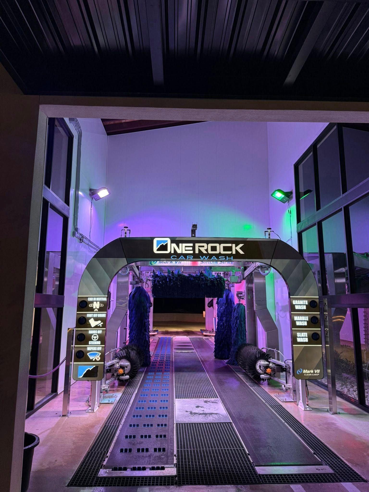 Car wash bay with blue and purple lighting, the name 