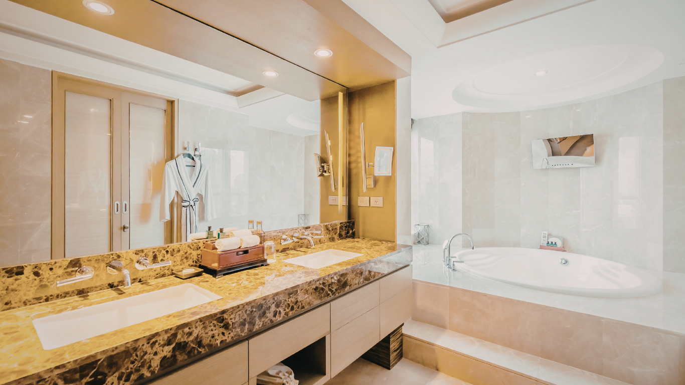 Modern luxury bathroom with double marble vanity, large mirror, and a white soaking tub by a light-colored tiled wall.
