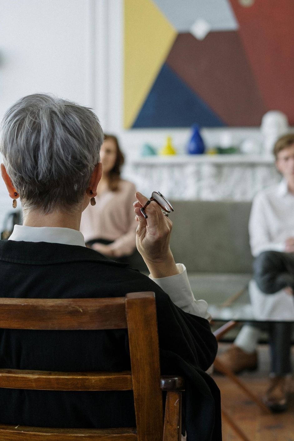 A woman is sitting in a chair talking to a group of people.